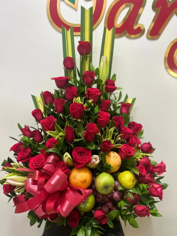 Arreglo floral piramide con rosas rojas y frutas