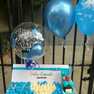 Caja con rosas azules y blancas, botella de Buchana's y globos con helio