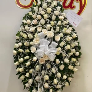 Corona funebre con rosas blancas.