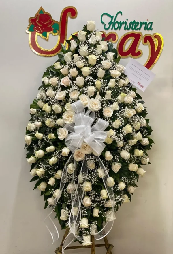 Corona funebre con rosas blancas.