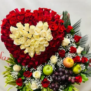 Arreglo floral en corazon con rosas rojas y blancas con frutas.