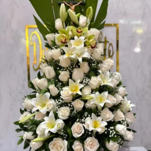 Arreglo funebre con rosas, lirios y cristo