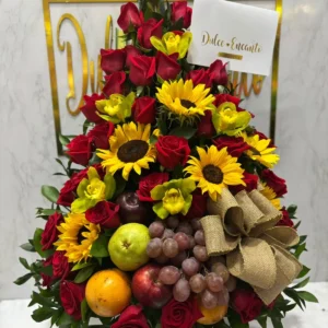 Arreglo floral con rosas, girasoles, orquideas y frutas